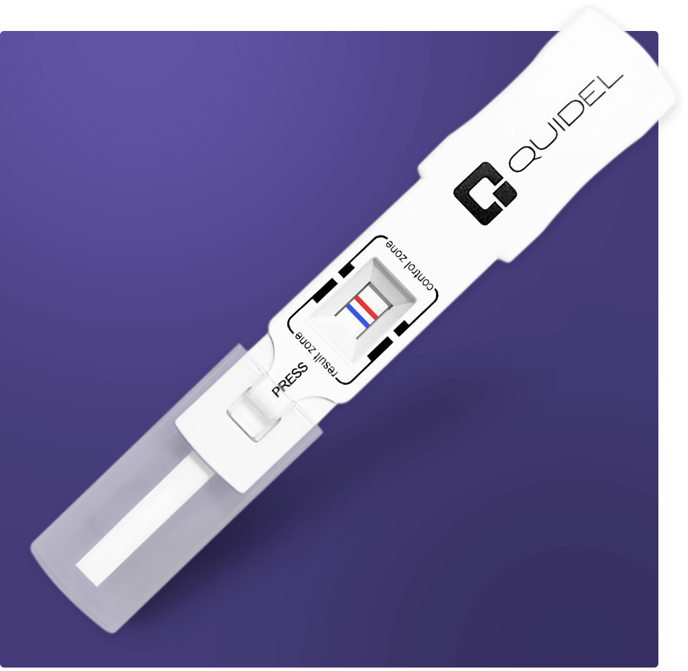 A white Quidel COVID-19 antigen test device on a purple background. The device shows one blue and one red line, indicating a positive test result. The words Control and Test are visible next to the lines.