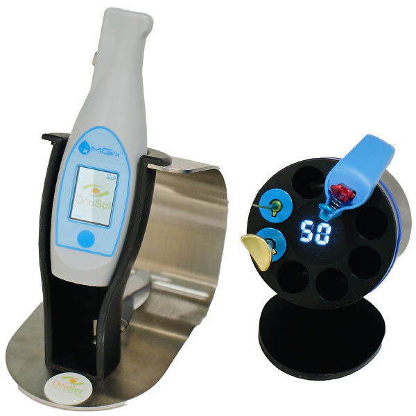 A digital medical device in a charging stand with a touch screen, next to a circular black holder with a blue digital display and attachments, including a yellow probe and a red tab on a blue band.