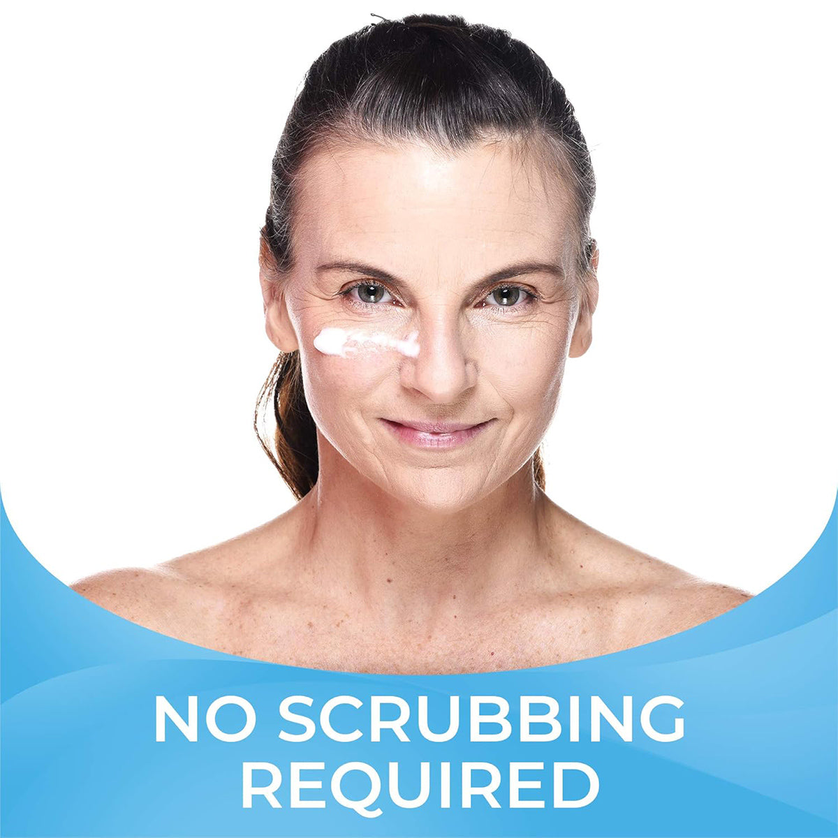 A woman with cream under one eye smiles against a white background. Bold text reads No scrubbing required, in a blue gradient, showcasing the magic of tea tree oil in PRNs Cliradex Light Foam Eyelash & Eyelid Cleanser for better ocular hygiene.