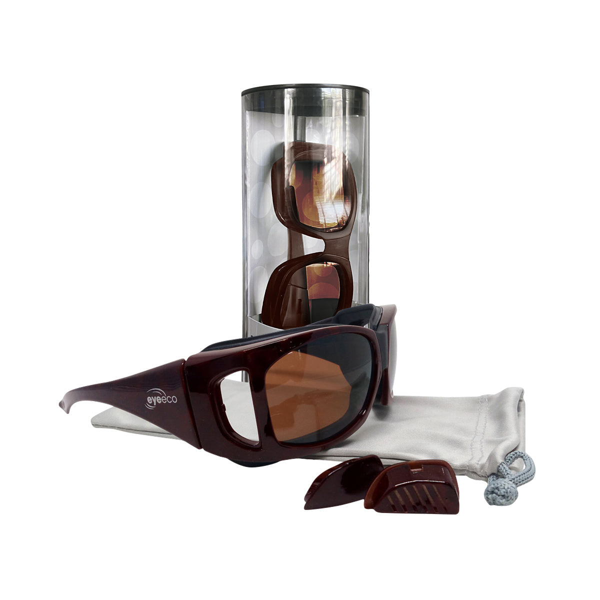 The EyeEco Large Moisture Release Eyewear by PRN, featuring a demi amber frame with copper lenses and detachable magnetic side shields, is elegantly displayed on a white microfiber bag. A transparent cylindrical case holds another pair. These sunglasses have an anti-fog coating for clear vision in varied conditions.