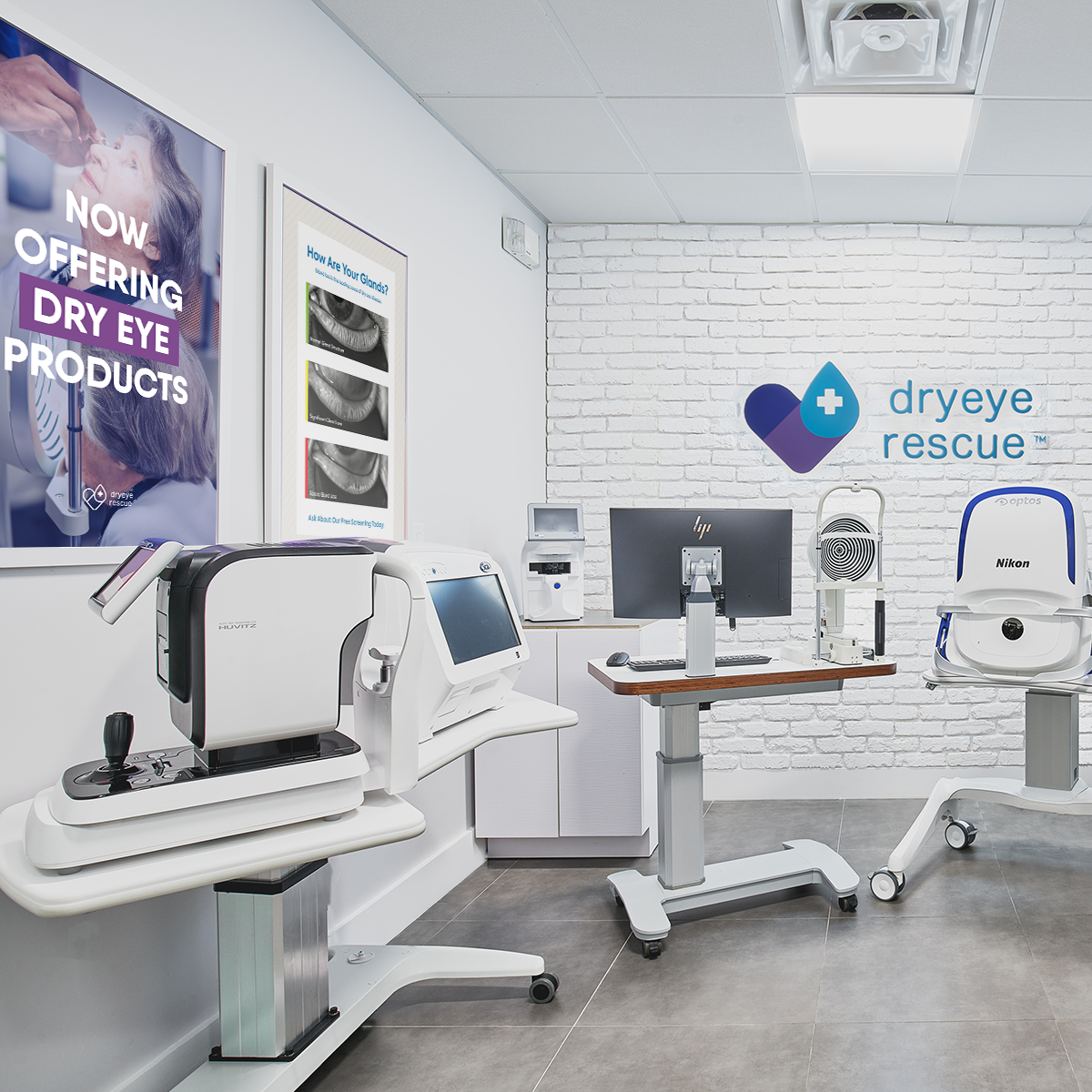 A modern eye care clinic displays diagnostic machines on wheeled stands, with gray flooring and white brick-detailed walls. A DryEye Rescue logo is on the wall next to a framed canvas sign in three colors, stating: Now Offering Dry Eye Products.