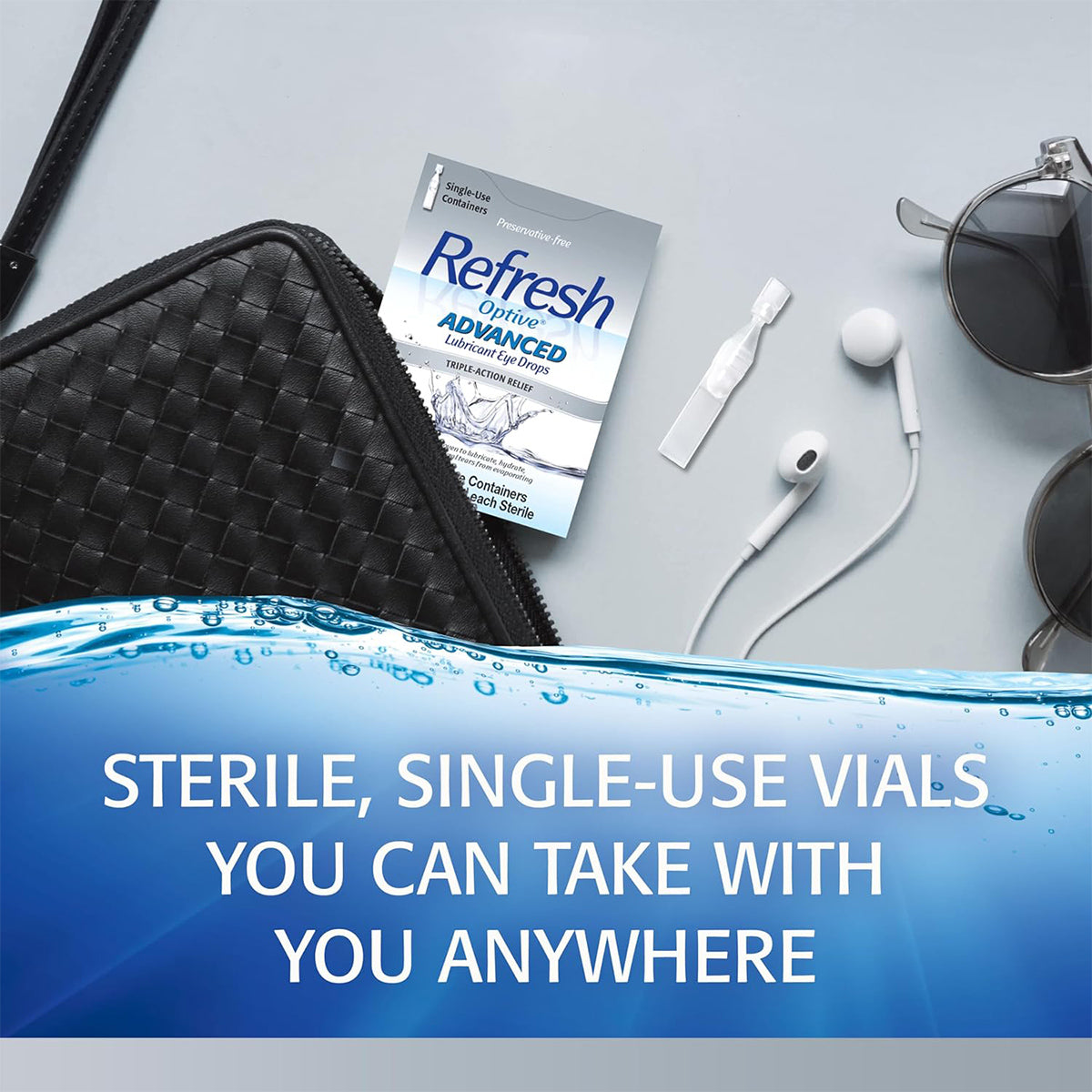 A box of Refresh Optive® Advanced Preservative-Free Lubricant Eye Drops by Abbvie is on a table with a woven bag, sunglasses, and earbuds. Text reads: Sterile single-use vials for dry eye relief anywhere.