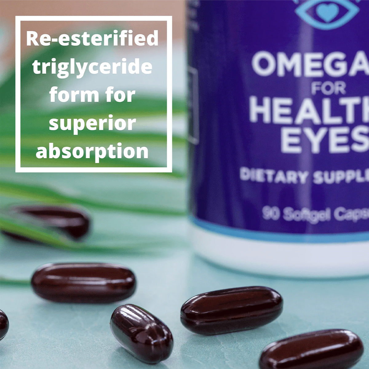Close-up of dark softgel capsules on a turquoise surface beside a bottle labeled Heyedrate Omega 3 For Eye Health (1 Month Supply). A text box reads, Re-esterified triglyceride form for superior absorption and enhanced eye health. Green leaves are in the background. Brand: PRN.