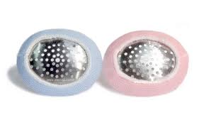 Two metallic soap holders from MedPharma USAs Eye Shield collection are displayed, resembling sleek aluminum eye shields. One has a light blue frame and the other a light pink frame, both elegantly set against a crisp white background.