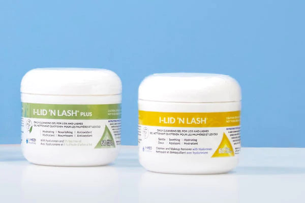 Two white jars labeled Lid N Lash. The left jar has a green label, and the right jar has a yellow label. Both jars are against a light blue background.