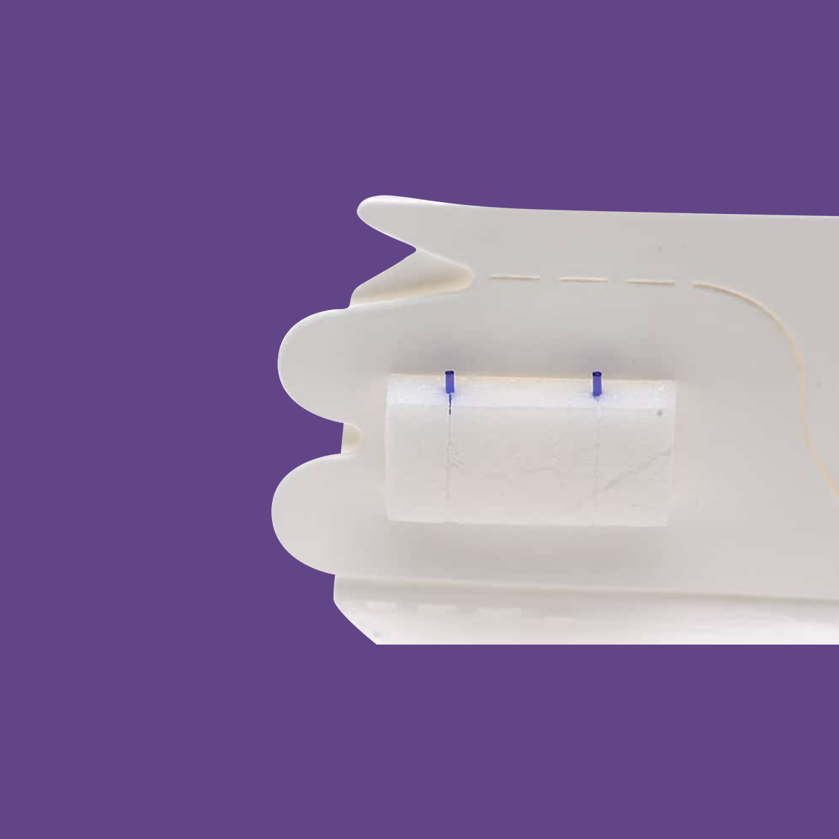 A white sculpture with abstract curves sits against a solid purple backdrop, echoing the delicate artistry involved in LASIK. Nearby is a small white block with two blue vertical lines, resembling Lacriveras Vera90 Synthetic Extended Inserts (90-Day Plugs) Absorbable (10-Pair).