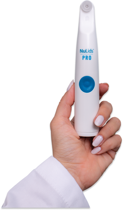 A person with manicured nails and a white sleeve holds the NuSight Medical NuLids Pro In-Office Eyelid Cleaner, designed for blepharitis/demodex. This innovative dry eye care device features a blue button and a small top brush, perfect for effective eyelid treatment.