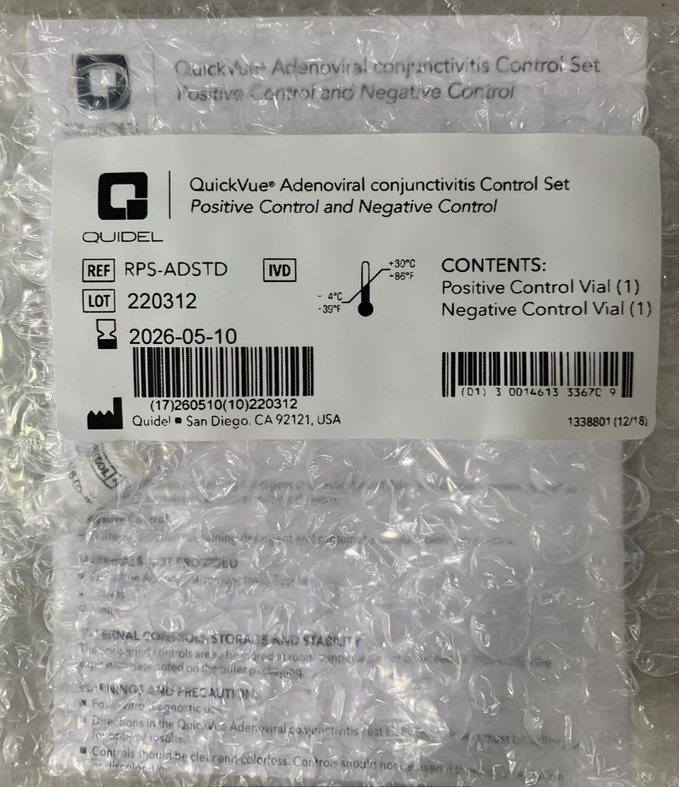 A sealed package contains a Quidel QuickVue AdenoViral Control Set with 1 Positive and 1 Negative Test. The label shows the reference number, lot number, expiration date, and contents: one Positive Control Vial and one Negative Control Vial.