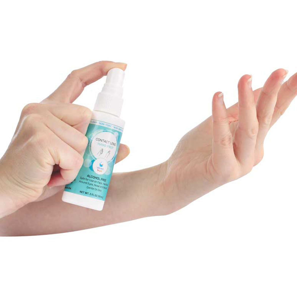 A person sprays Vibrant Vue Contact Lens Hand Prep by Visionary Optics onto their forearm. The Alcohol Free bottle with a subtle logo contains hypochlorous acid for effective cleaning and is set against a plain white background.