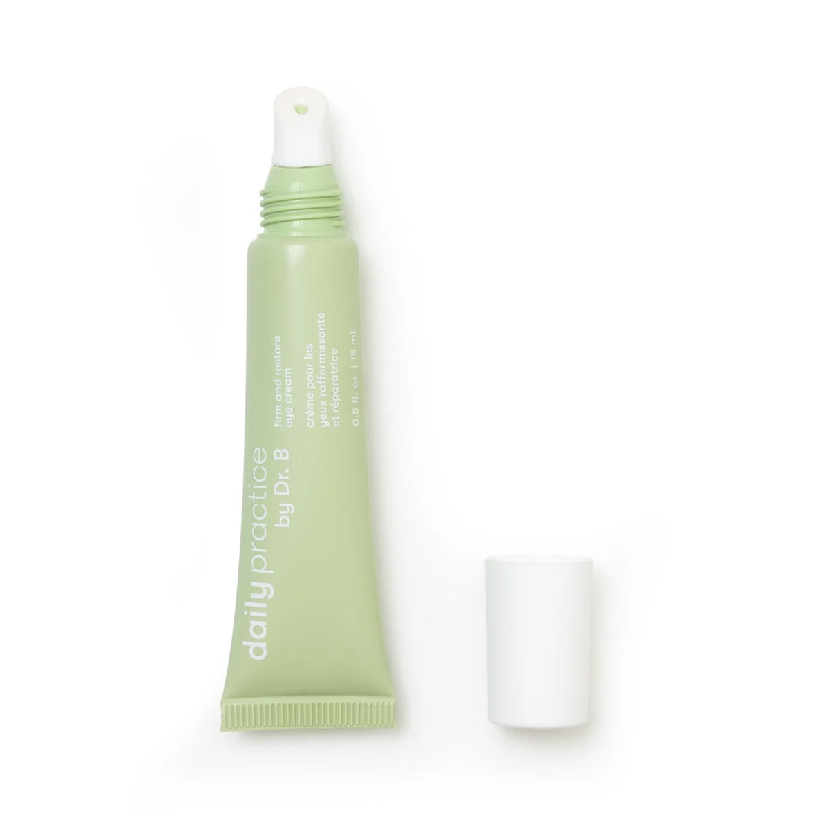 A small, green tube of lip balm with daily practice by Dr. B and repair and nourish tinted lip balm for hydration in white text sits against a plain white background, complemented by the firming qualities of the Daily Practice Firm & Restore Eye Cream (15mL).