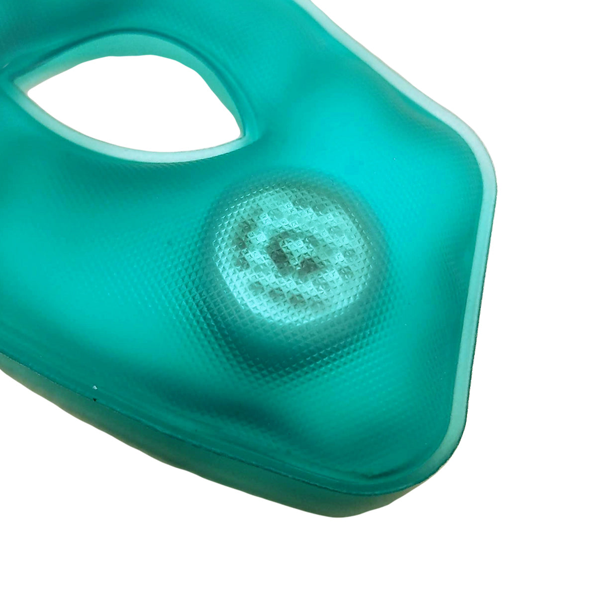 Close-up of a turquoise gel eye mask from TearRestore, designed for dry eye relief. It features a textured surface with a central opening and a visible raised circular disc. Surrounded by smooth, cushioned edges, it offers soothing heat therapy; includes two replacement heat packs for 6 months use.