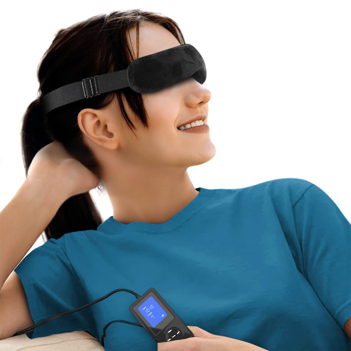 A person in a blue shirt relaxes on a sofa, smiling while wearing the black Wizard Research USB Heated Eye Mask. Featuring graphene infrared technology for heat therapy, its connected to a compact control device. The white background highlights the individual.