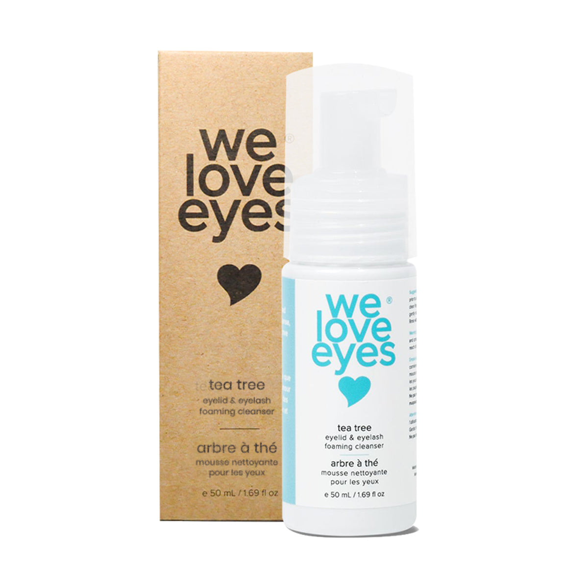 A 25mL mini We Love Eyes Tea Tree Eyelid & Eyelash Foaming Cleanser bottle shows a light blue heart on white, with an anti-inflammatory formula, placed in front of matching brown packaging featuring the brands design.